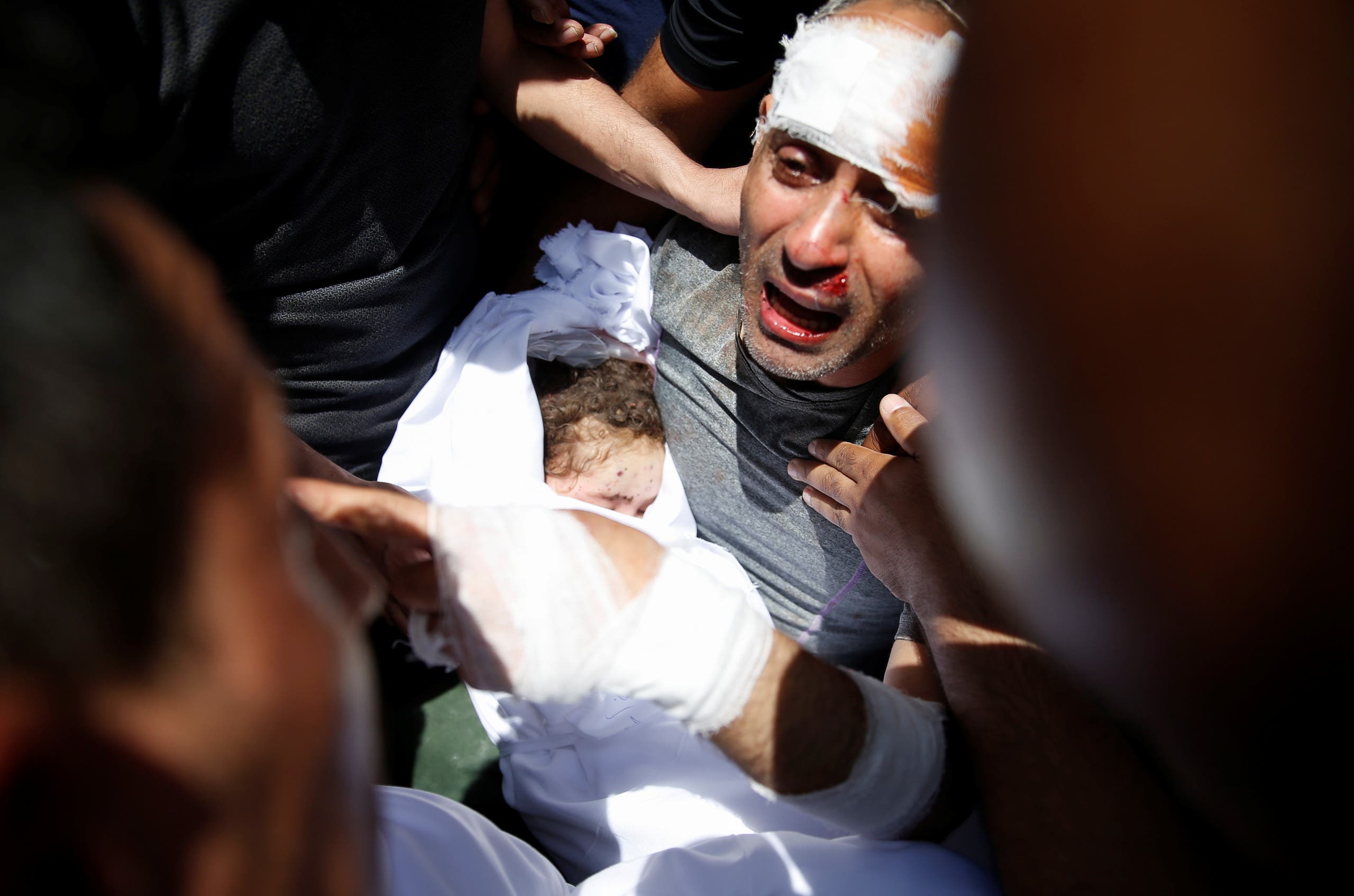 رجل يحمل جثة طفله المتوفي إثر غارة إسرائيلية في غزة