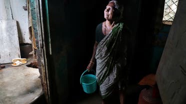 A woman stands as she removes water from her house after Cyclone Nivar's landfall, in Chennai, India, November 26, 2020. (File photo: Reuters)
