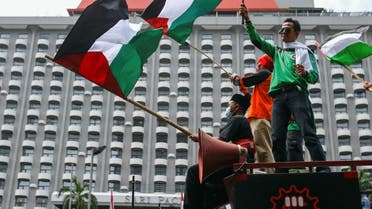 Members of Indonesian labour organizations wave Palestinian flags during a protest against Israel outside the United Nations building in Jakarta, Indonesia, May 18, 2021. (Reuters)