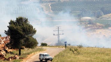 A UN peacekeeper (UNIFIL) stands as smoke rise in the southern Lebanese village of Khiam, near the border with Israel, Lebanon May 14, 2021. (Reuters)