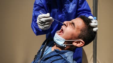 A young Palestinian man reacts as a health worker collects a nasal swab sample for a coronavirus test at a local clinic in Gaza city, on April 29, 2021. (AFP)