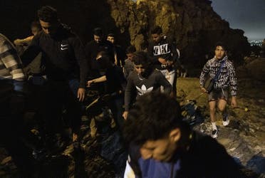 Moroccan migrants climb a cliffside on the shore of the northern town of Fnideq as they attempt to cross the border from Morocco to Spain's North African enclave of Ceuta on May 18, 2021(File photo: AFP)