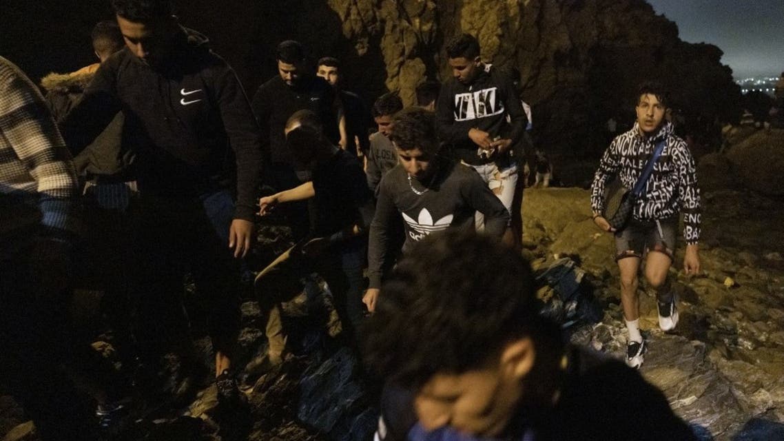 Moroccan migrants climb a cliffside on the shore of the northern town of Fnideq as they attempt to cross the border from Morocco to Spain's North African enclave of Ceuta on May 18, 2021(File photo: AFP)
