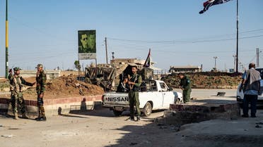 Members of the Syrian Kurdish internal security services known as “Asayish” and Syrian government forces man a checkpoint in the al-Tay neighborhood of Syria’s northeastern city of Qamishli on April 27, 2021. (Delil Souleiman/AFP)
