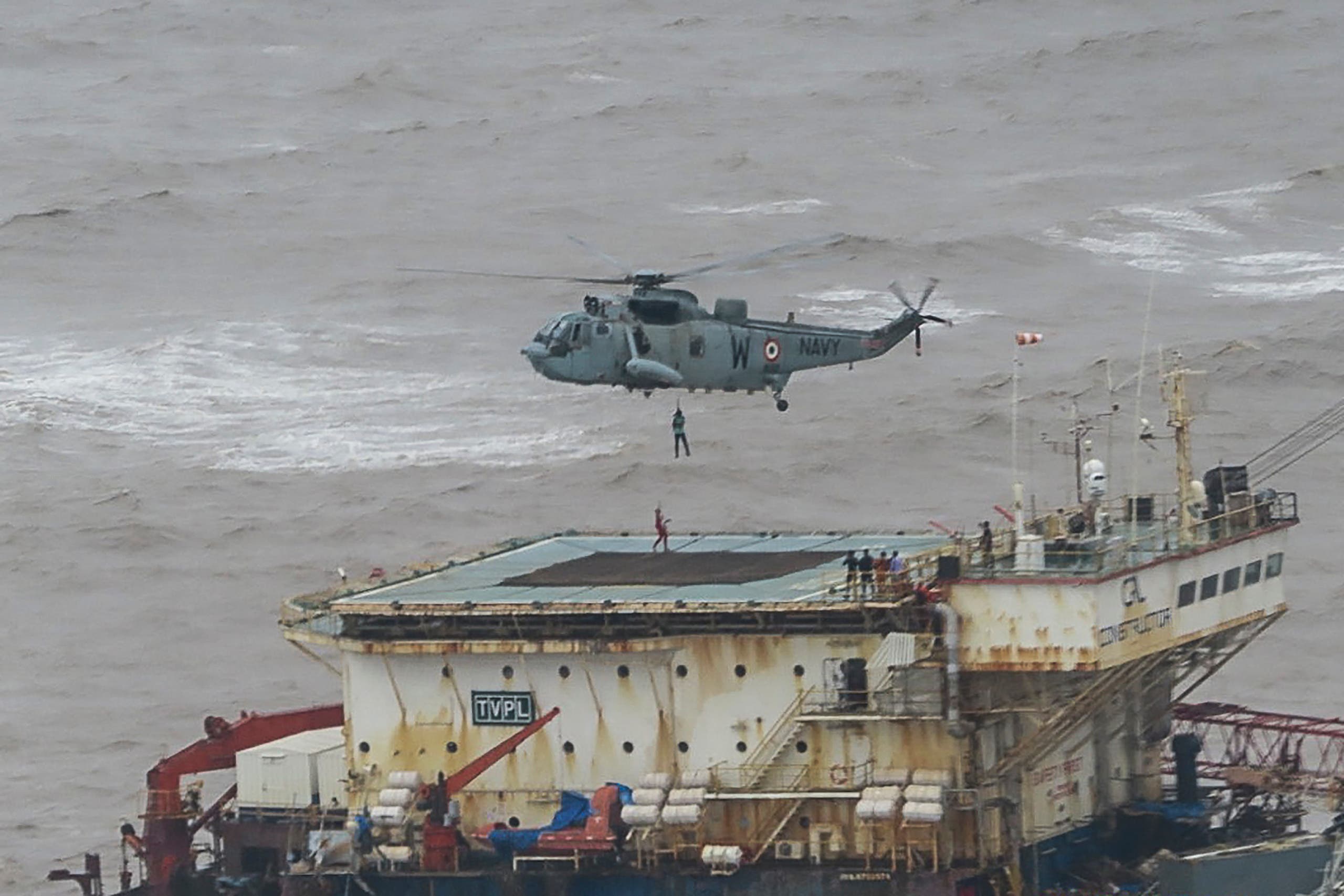 This handout photograph taken on May 18, 2021 and released by the Indian Navy shows stranded workers from a barge, which had gone adrift amidst heavy rain and strong winds due to Cyclone Tauktae, being airlifted by naval personnel on an Indian Navy Seaking helicopterduring an evacuation operation, in the Arabian sea. At least 27 people were dead and more than 90 missing on May 18 after a monster cyclone slammed India, compounding the country's woes as it recorded a new record number of coronavirus deaths in 24 hours. (File photo: AFP)