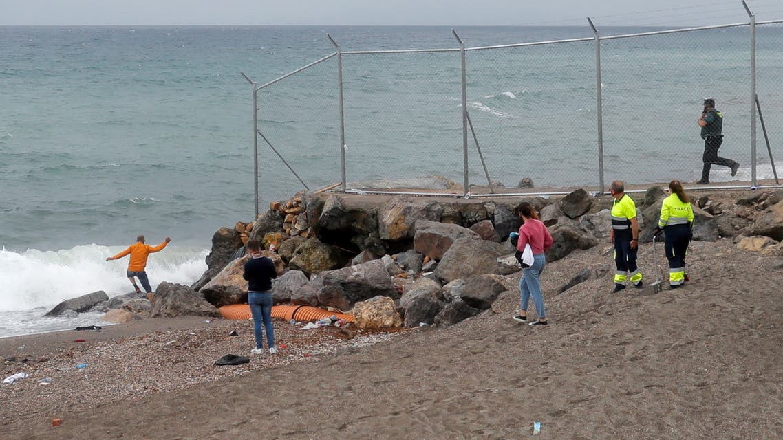 A man is seen near the fence at the Spanish-Moroccan border as he tries to enter Morocco, after thousands of migrants swam across this border during the last days, in Ceuta, Spain, May 20, 2021. REUTERS/Jon Nazca