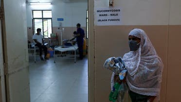 A woman stands outside as a patient infected with black fungus is treated at the Mucormycosis ward of a government hospital in Hyderabad, India, Thursday, May 20, 2021. (AP Photo/Mahesh Kumar A.)