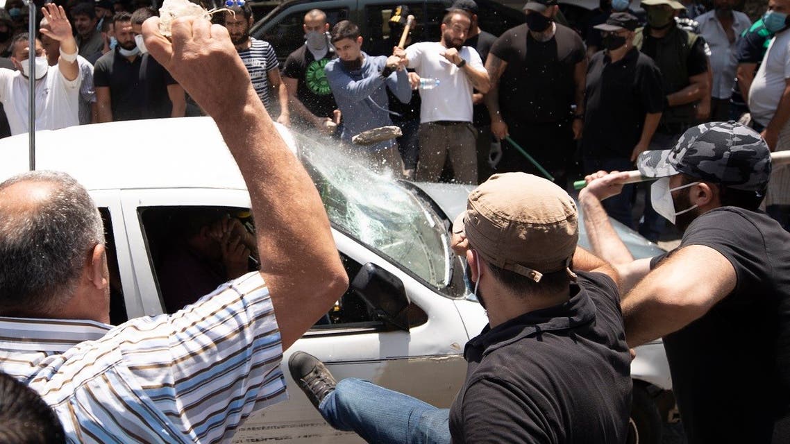 Supporters of the Lebanese Forces group attack a car carrying Syrian voters before heading to the Syrian embassy to vote, north of Beirut, Lebanon, May 20, 2021. (AP)