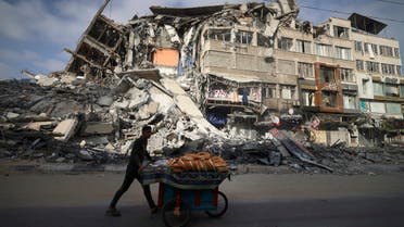 A Palestinian man walks past the destroyed Al-Shuruq building in Gaza City on May 20, 2021 after it was bombed by an Israeli air strike. (AFP)