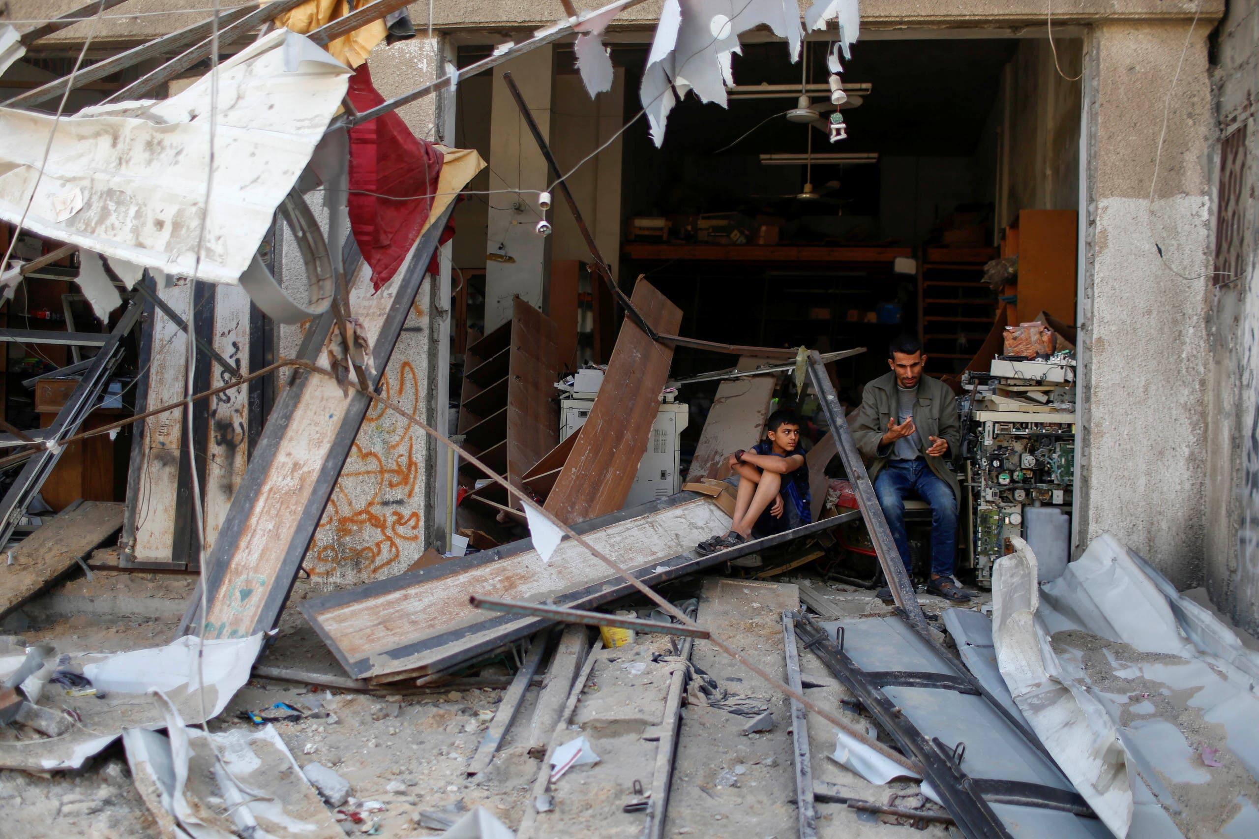 Palestinians sit amidst the damage in the aftermath of Israeli air strikes, amid Israeli-Palestinian fighting, in Gaza, May 20, 2021. (Reuters)