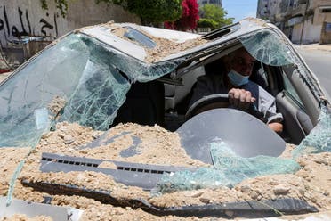 فلسطيني داخل سيارته التي دمرها القصف الإسرائيلي على غزة