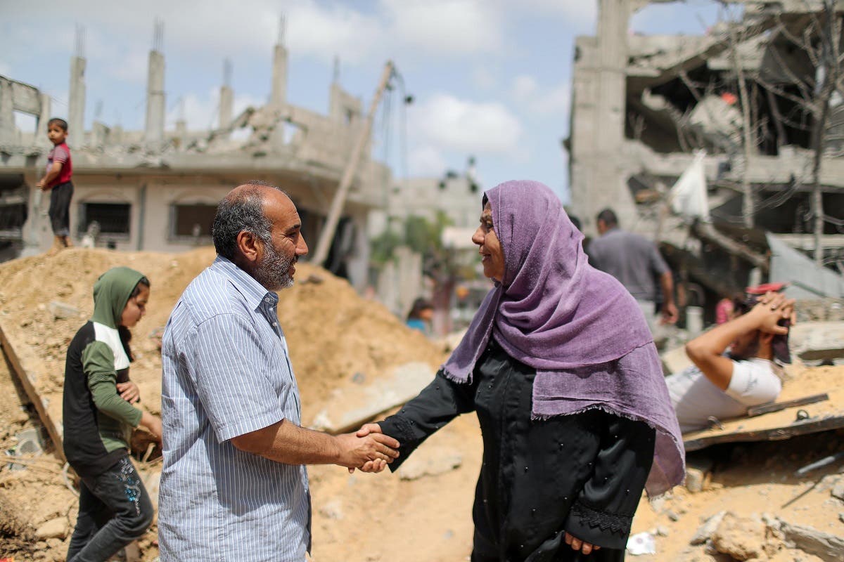 Palestinians shake hands after returning to their destroyed houses following Israel- Hamas truce, in Beit Hanoun in the northern Gaza Strip, May 21, 2021. (Reuters)
