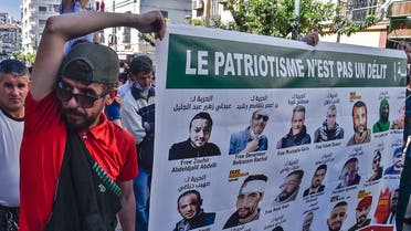 Algerians hold signs with portraits of activists held in jail, during an anti-government demonstration in the capital Algiers on May 7, 2021. (AFP)