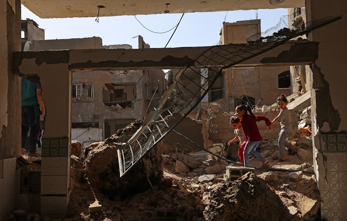 Palestinian children walk amidst the rubble of buildings, destroyed by Israeli strikes, in Beit Hanun in the northern Gaza Strip on May 21, 2021. (Reuters)