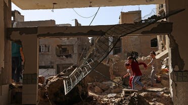 Palestinian children walk amidst the rubble of buildings, destroyed by Israeli strikes, in Beit Hanun in the northern Gaza Strip on May 21, 2021. (Reuters)