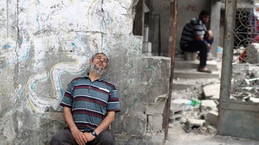 فلسطيني يجلس بجانب حطام منزله في غزة