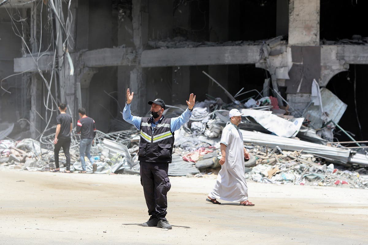 A Palestinian policeman directs traffic near a building damaged in Israeli missile strikes in the recent cross-border violence between Palestinian militants and Israel, following Israel-Hamas truce, in Gaza City May 21, 2021. (Reuters)