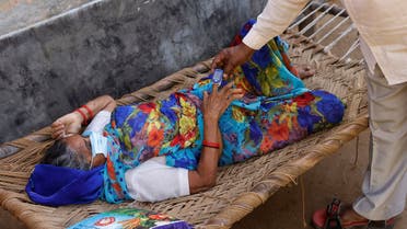 Moorti, 62, a villager suffering from fever rests on a cot as she waits to receive treatment at a clinic set up by a local villager, amidst the spread of the coronavirus disease (COVID-19), in Parsaul village in Greater Noida, in the northern state of Uttar Pradesh, India, May 22, 2021. REUTERS/Adnan Abidi