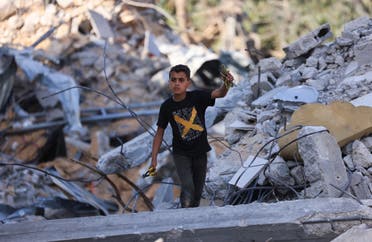 A Palestinian boy inspects the rubble of buildings, destroyed by Israeli strikes, in Beit Lahia in the northern Gaza Strip. (AFP)