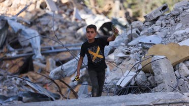 A Palestinian boy inspects the rubble of buildings, destroyed by Israeli strikes, in Beit Lahia in the northern Gaza Strip on May 21, 2021. A ceasefire in the conflict between Israel and Palestinian militants in the Gaza Strip, controlled by Islamist group Hamas, came into effect after 11 days of airstrikes and rocket fire.