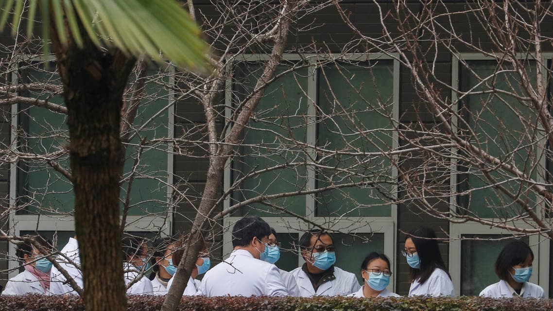 Chinese scientists and officials in lab coats wait at the Hubei Animal Epidemic Disease Prevention and Control Center during a visit of a team of the World Health Organization (WHO), tasked with investigating the origins of the coronavirus disease (COVID-19), in Wuhan, Hubei province, China February 2, 2021. (File photo: Reuters)