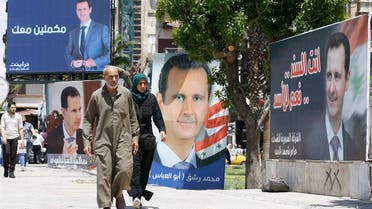 People walk next to election campaign billboards depicting Syrian President Bashar al-Assad, a candidate for the upcoming presidential vote, in Damascus. (File Photo: AP)