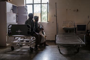 شخصان يحلسان داخل مستشفى في تيغراي تم نهب ممتلكاته 
