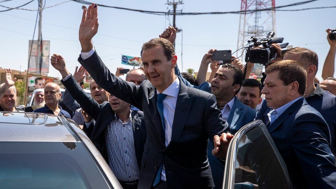 Syrian President Bashar Assad, right, waves for his supporters at a polling station during the Presidential elections in the town of Douma, near Damascus, May 26, 2021. (AP)