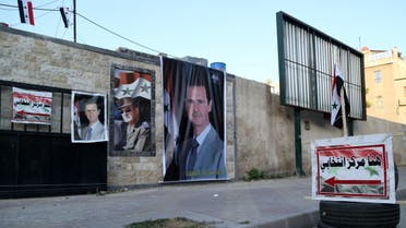 Posters of Syria’s President Bashar al-Assad are seen outside a polling station before polls open for the presidential elections, in Damascus, Syria May 26, 2021. (Reuters)