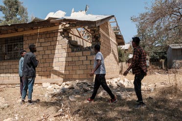 شباب يعاينون الدمار الذي لحق بالمباني في تيغراي بسبب القتال