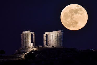 The flower full moon rises behind the Temple of Poseidon (neptun) at Cape Sounion, some 70 km south of Athens on May 26, 2021. (AFP)