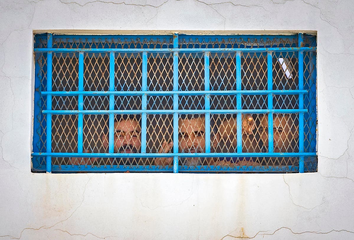 Prisoners watch from behind their cell window during a vaccination campaign against the coronavirus, at the El-Arjate prison near the capital Rabat, on May 26, 2021. (Fadel Senna/AFP)