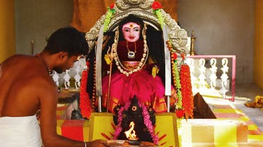 In this picture taken on May 19, 2021, a priest (L) performs Aarti, a prayer ritual in front of an idol locally known as 'Corona Devi', believed to be safeguarding people from the Covid-19 coronavirus at Kamatchipuri Adhinam temple in Coimbatore. (File photo: AFP)