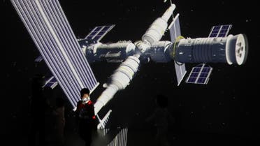 FILE PHOTO: A child stands near a giant screen showing the images of the Tianhe space station at an exhibition featuring the development of China's space exploration on the country's Space Day at China Science and Technology Museum in Beijing, China April 24, 2021. REUTERS/Tingshu Wang/File Photo