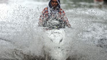 A person rides a scooter through a waterlogged road during monsoon rain showers in Mumbai, India, June 4, 2020. (Reuters)