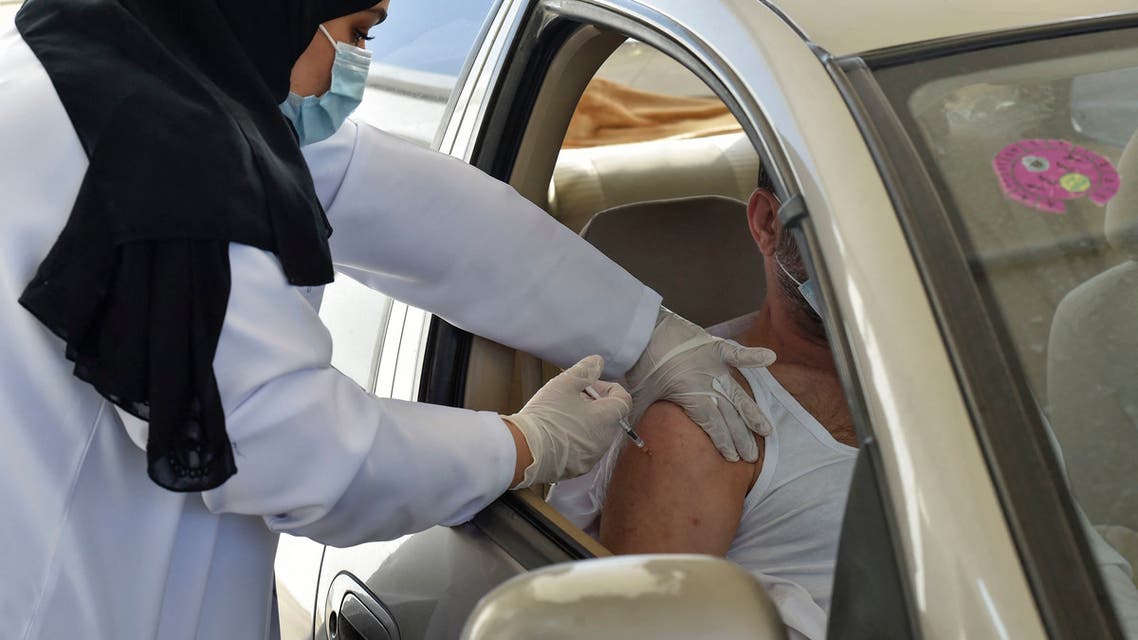 A medical worker administers a dose of the AstraZeneca COVID-19 vaccine at the first drive-through vaccination center in the Saudi capital Riyadh, on March 4, 2021. (AFP)