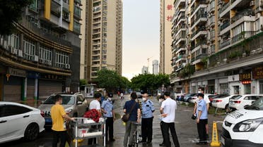Police officers speak to people behind a police line near a residential area where only entering is allowed, following new cases of the coronavirus disease (COVID-19), in Guangzhou's Liwan district, Guangdong province, China May 29, 2021. (Reuters)