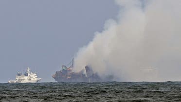 An Indian Coastguard ship (L) tries to douse off the fire as smoke billows from the Singapore-registered container ship MV X-Press Pearl, on a beach in Colombo on May 31, 2021. (Lakruwan Wanniarachchi/AFP)