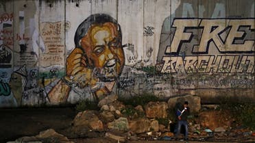 صورة تم التقاطها في 31 مارس 2021 بالقرب من حاجز قلنديا الإسرائيلي ، بين القدس ورام الله ، تظهر لوحة جدارية للأاسير الفلسطيني من حركة فتح مروان البرغوثي 