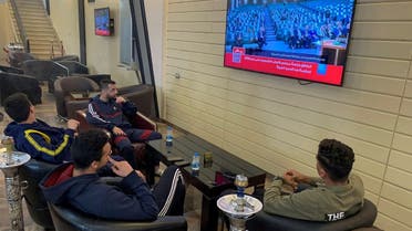 People watch Libya’s parliament meet to vote on a unity government on a TV screen at a cafe in Misrata, Libya, on March 10, 2021. (Reuters)