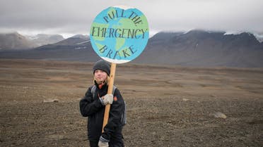 An Icelandic girl poses for a photo with a Pull the emergency brake sign near to where a monument was unveiled at the site of Okjokull, Iceland's first glacier lost to climate change in the west of Iceland on August 18, 2019. (AFP)