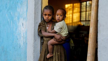 An 11-year-old girl holds her one-year-old brother Barakat at the doorway to a classroom now used as their living space, at the Tsehaye primary school, which was turned into a temporary shelter for people displaced by conflict, in the town of Shire, Tigray region, Ethiopia, March 15, 2021. (File Photo: Reuters)