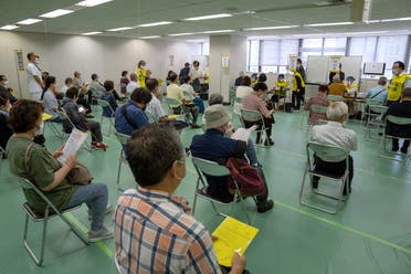 People wait to be processed after arriving to receive the Moderna coronavirus disease (COVID-19) vaccine at the newly-opened mass vaccination center in Tokyo, Japan, May 24, 2021. (Reuters)