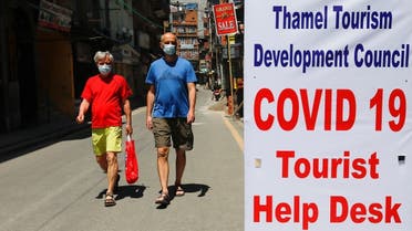 Tourists walk next to a COVID-19 tourist help desk in Thamel, a major tourist hub, amidst the coronavirus pandemic in Kathmandu, Nepal, May 14, 2021. (Reuters/Navesh Chitrakar)