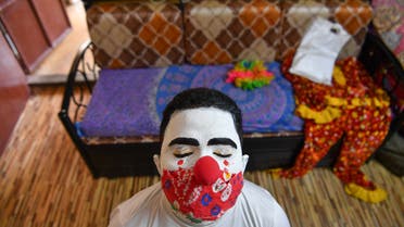 Social worker volunteer Ashok Kurmi, waits for his make-up to dry as he dresses like a clown before going into slums to start a sanitation work and spread awareness to follow the Covid-19 coronavirus safety protocols, at his home in Mumbai on June 2, 2021. (File photo: AFP)