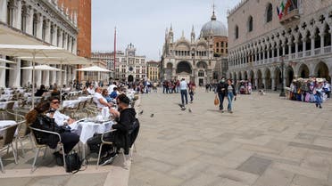 People sit at outdoor tables at St. Mark’s Square as Italy lifts quarantine restrictions for travelers arriving from EU countries in Venice, Italy, May 16, 2021. (Reuters/Manuel Silvestri)