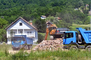 A digger is pictured next to pile of rubble coming from a demolished illegally constructed Serbian Orthodox church in Konjevic Polje, Eastern Bosnia on June 5, 2021, which was built in 1998 on land near Srebrenica, seized from Fata Orlovic, a Muslim refugee after the 1992-1995 civil war. (AFP)