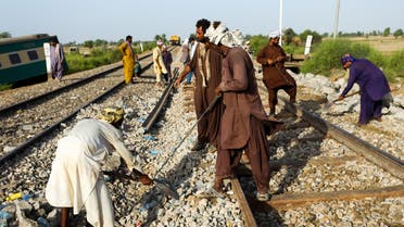 Railway workers fix the track in Daharki on June 8, 2021, a day after a packed inter-city train ploughed into another express that had derailed, killing at least 63 people. (File photo: AFP)