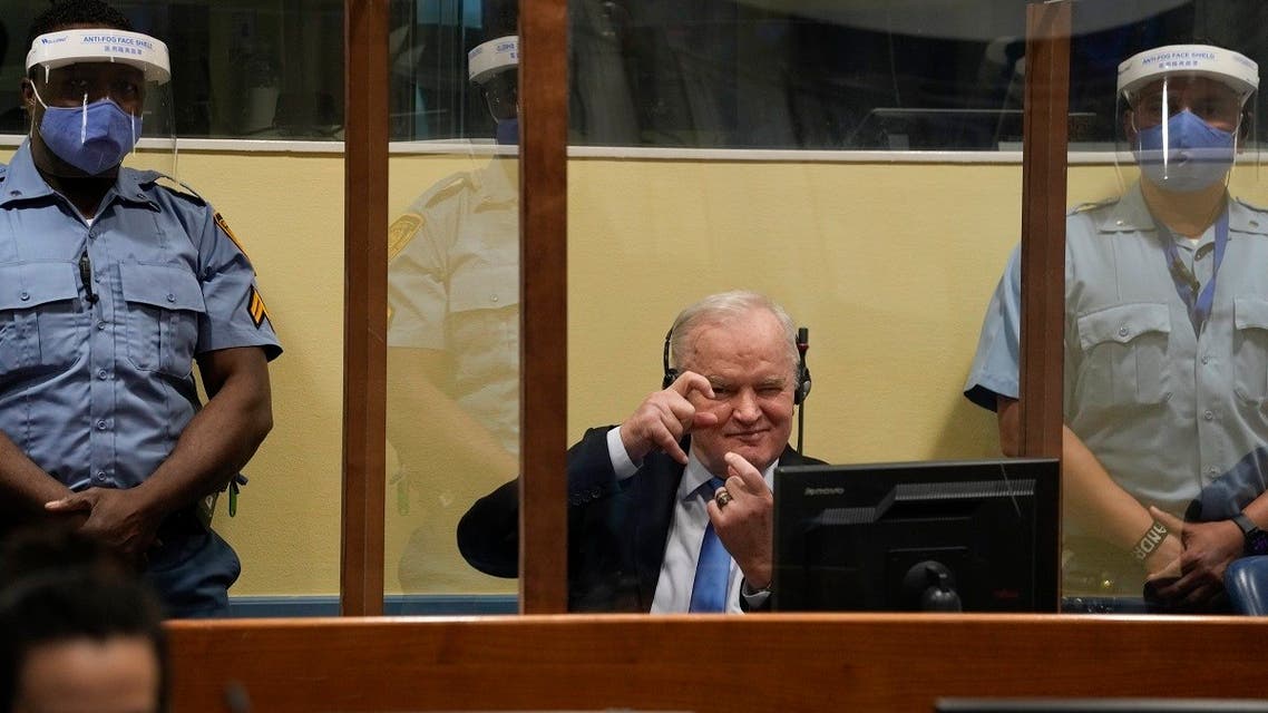 Former Bosnian Serb military chief Ratko Mladic imitates taking pictures as he sits the court room in The Hague, Netherlands, June 8, 2021. (AP/Peter Dejong/ Pool)