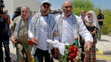 Palestinian-Jordanian Abdullah Abu Jaber, who was jailed in Israel after planting a bomb on a bus that wounded 13 civilians in 2000, is welcomed by his family upon his release at the Sheikh Hussein Crossing between Jordan and Israel on June 8, 2021. (AP)